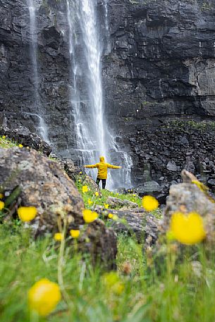 Tourist at the Foss waterfall, the highest waterfall in the Faroe Islands, Streymoy island, Faeroe islands, Denmark, Europe
